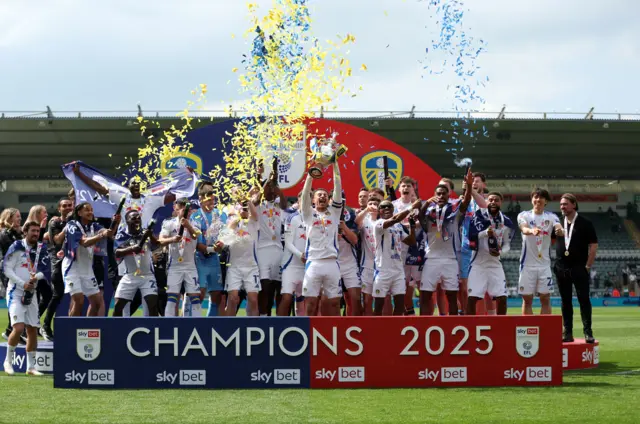 Leeds United players lift the Championshop trophy