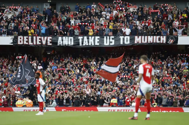 Arsenal fans with a banner inside the stadium before the match