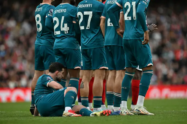 Lewis Cook sits on the pitch