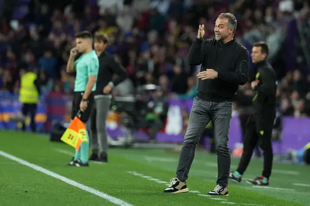 Hansi Flick raises his arm on the touchline