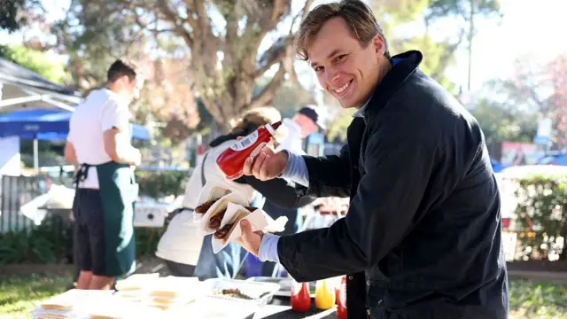 A voter enjoys a sausage, known informally as 