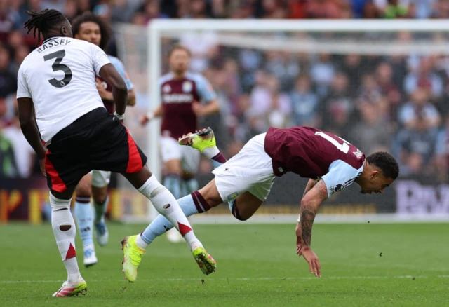 Fulham's Calvin Bassey in action with Aston Villa's Morgan Rogers