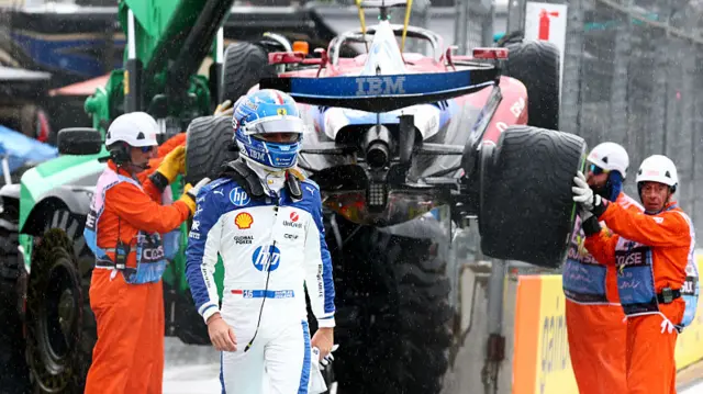 Charles Leclerc walks away from his crashed Ferrari at the Miami Grand Prix, as the car is lifted on to a truck