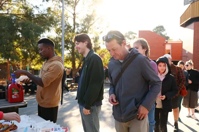 People in Melbourne queue up to buy democracy sausages at Brunswick East Primary School in Melbourne.
