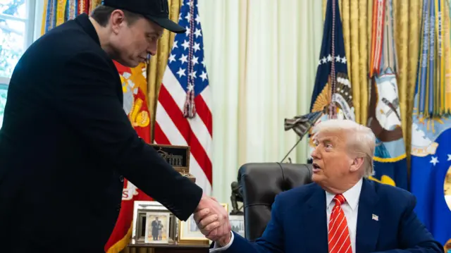 US President Donald Trump (R) and Elon Musk shake hands during a press conference in the Oval Office