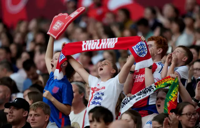 Fan holds a scarf aloft and sings after the two early goals