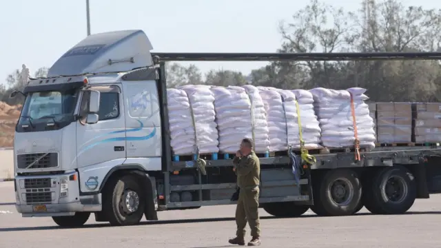 An Israeli soldier stands next to a truck with humanitarian aid bound for Gaza at the Kerem Shalom crossing on the Gaza-Israel border in southern Israel on 29 May