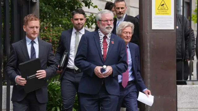 Gerry Adams leaving court with his team