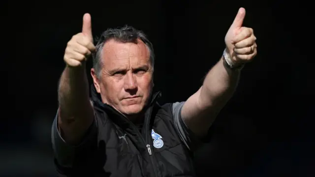 Oldham boss Micky Mellon gives the thumbs-up to supporters