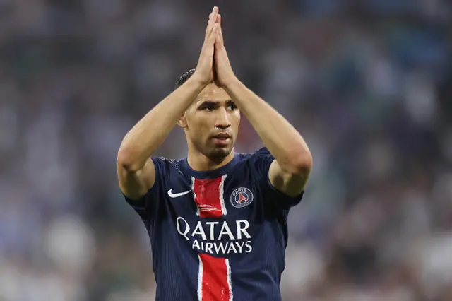Achraf Hakimi of Paris Saint-Germain holds up his hands as he celebrates