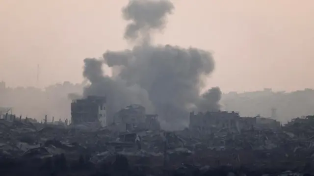 Plumes of smoke rise from destroyed buildings and rubble in Gaza.
