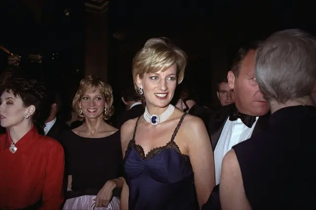 Princess Diana wearing a navy blue lingerie gown and pearl choker necklace, with an enormous sapphire and diamond clasp.