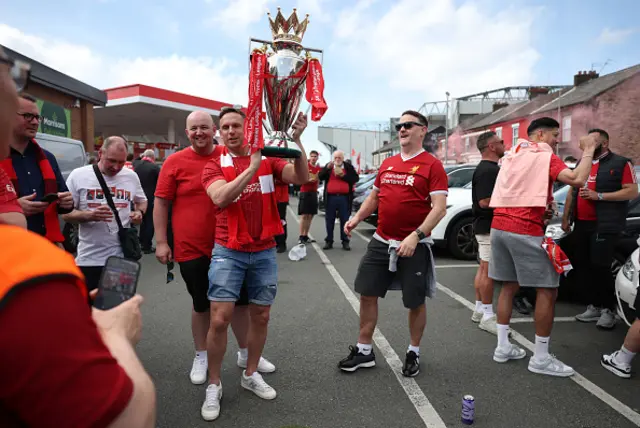 Fan of Liverpool poses for a photo while holding a replica