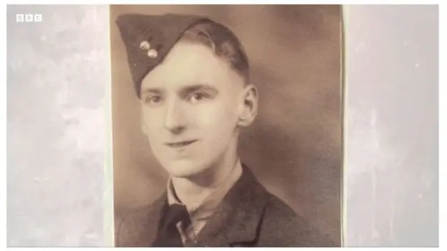 A sepia photo of a young soldier wearing a dark uniform, shirt and tie ad a dark side cap