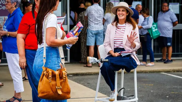Labor candidate for Dickson, Ali France, hands out flyers at a pre-polling centre on 2 May 2025