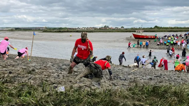 A team in red shirts are stuck in the mud