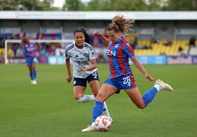 Katie Stengel of Crystal Palace crosses the ball whilst under pressure from Asmita Ale of Leicester City during the Barclays Women's Super League match between Crystal Palace and Leicester City at VBS Community Stadium on May 04, 2025 in Sutton, England.