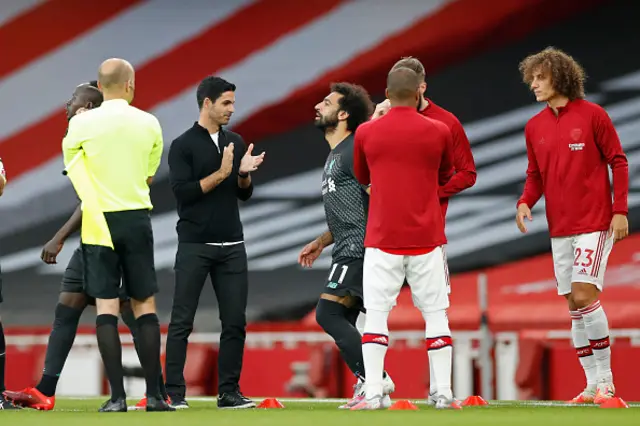 Arsenal's Spanish head coach Mikel Arteta (3rd L) applauds the Liverpool players on to the pitch as part of a guard of honour