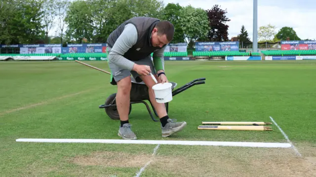 Groundsman paints lines on pitch