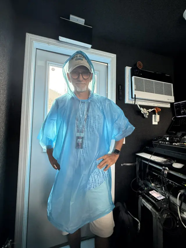 Dmaon Hill wearing a poncho in the commentary box in Miami