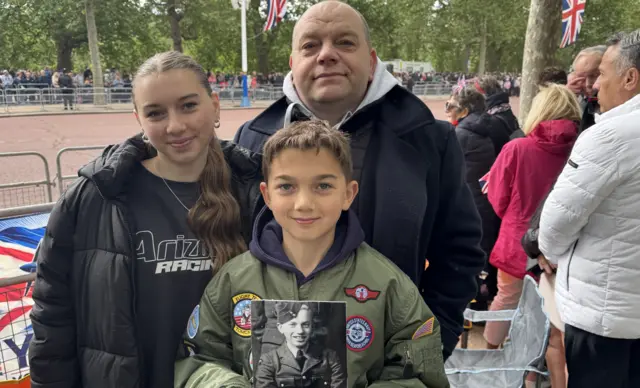 Neil Brown stands on The Mall with his two children, Xander holds an image of his grandfather