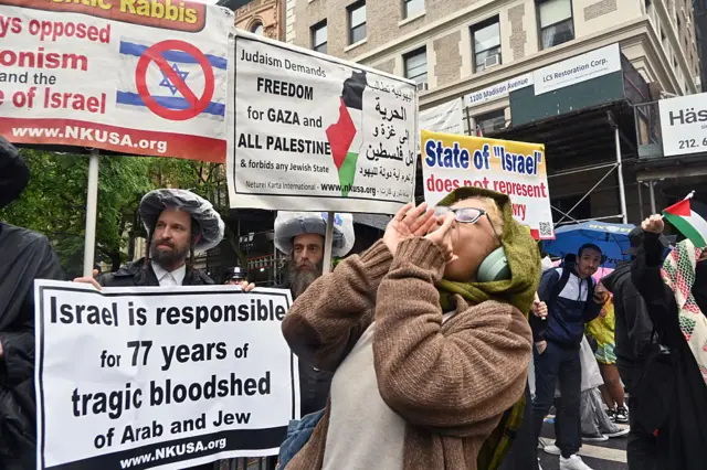 Protestors holding banners with signs against the war in Gaza