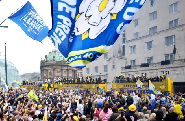 Three buses make their way through the city centre to the adulation of supporters