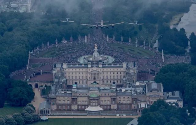 A Lancaster flanked by two Spitfires of the Battle of Britain Memorial Flight fly over Buckingham Palace