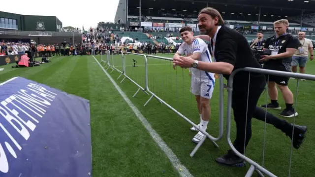 Daniel Farke, dressed in black, and Dan James, in Leeds kit, speak to United fans in Plymouth after the game