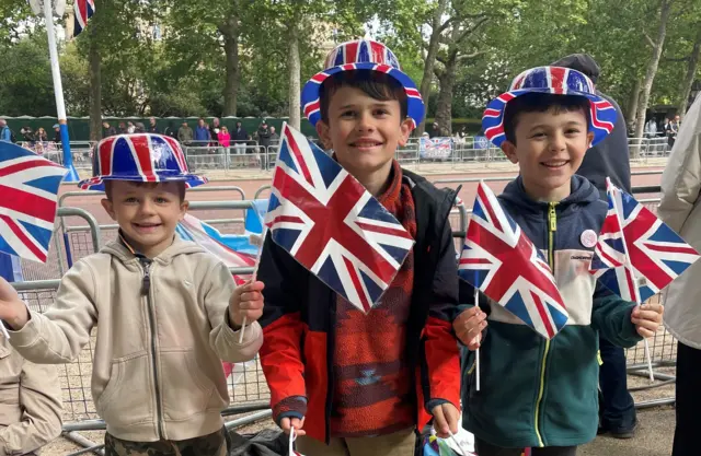 Three young boys standing on The Mall with Union Jack flags