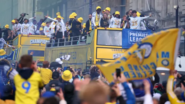 Fans cheering as the buses make their way through town.
