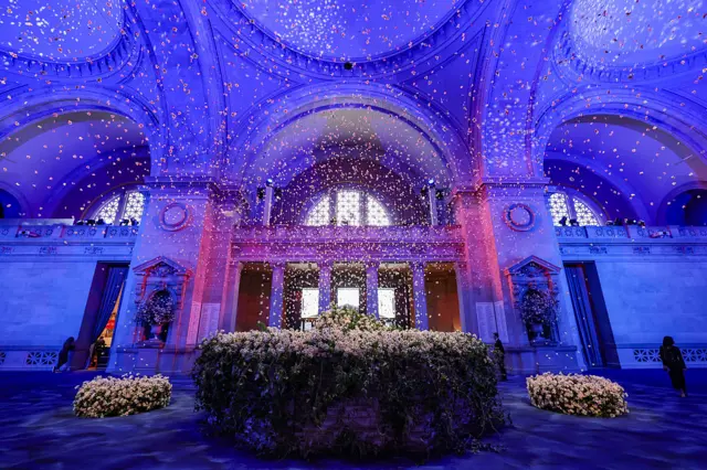 The interior of the Metropolitan Museum of Art in Manhattan is decked out for the gala with purple and pink lighting and lots of florals.