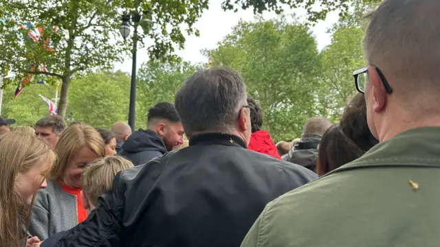 A view of people facing away as crowds build up