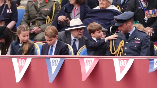 Prince William sits next to children while Prince Louis touches William on the shoulder