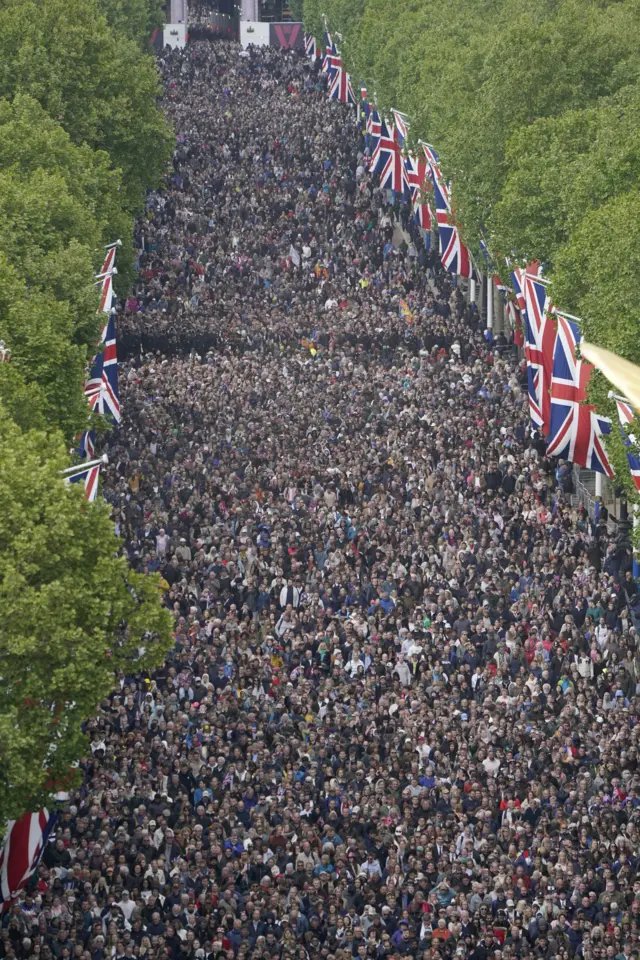 Members of the public walk up The Mall, near Buckingham Palace