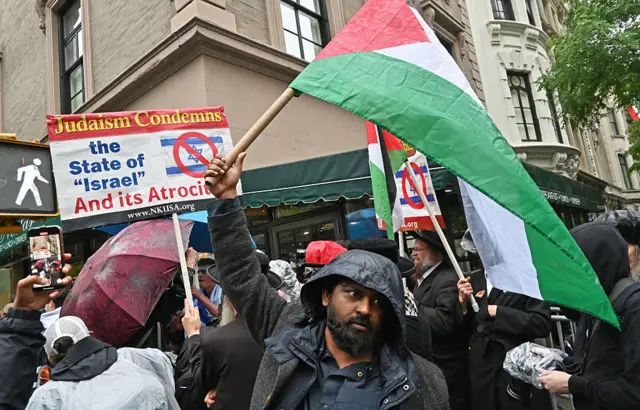 Protestors holding banners with signs against the war in Gaza