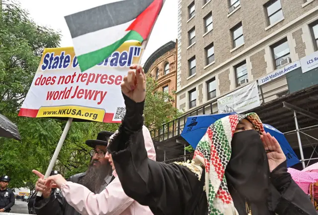 Protestors holding banners with signs against the war in Gaza