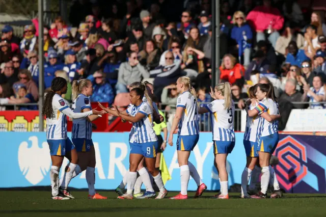 Brighton players celebrate a goal at home in front of their fans