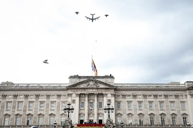 A pigeon flies past as planes fly over Buckingham Palace following a procession