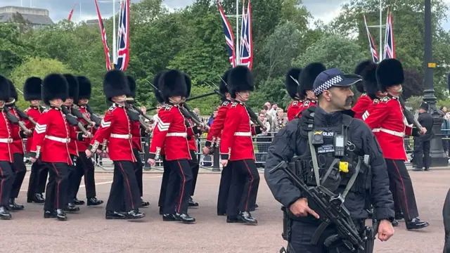 Policeman stands with a gun as parade goes by