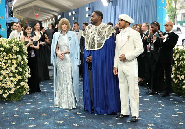 Anna Wintool (à gauche) se dresse à côté de l'acteur Colman Domingo et du pilote de Formule 1 Sir Lewis Hamilton.