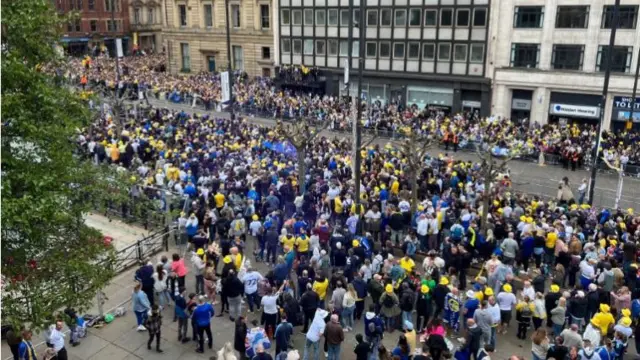 Crowds line a city street