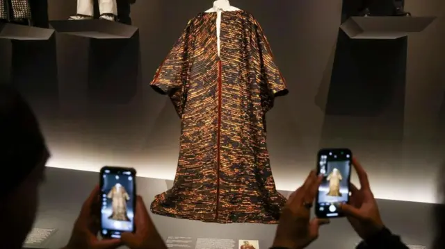 People take photos of a fashion piece worn by late American fashion journalist Andre Leon Talley, who is said to have inspired this exhibit, during the press preview for the opening of The Met's Costume Institute exhibition 'Superfine: Tailoring Black Style' at the Metropolitan Museum of Art in New York, New York, USA, 05 May 2025.