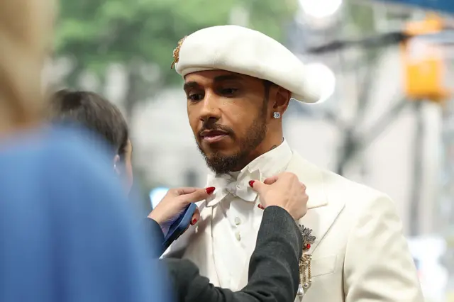 Lewis Hamilton wearing a white tux and white beret at the Met Gala.