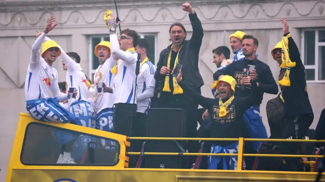 Leeds United players and manager Daniel Farke celebrate on top of the bus