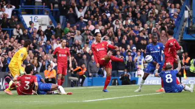 Virgil van Dijk kicks the ball against team-mate Jarell Quansah as Liverpool concede an own goal against Chelsea