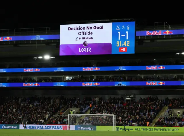 The big screen displays a VAR review message