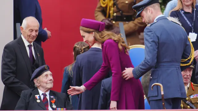 Princess of Wales greets a World War Two veteran while the Prince of Wales stands behind her
