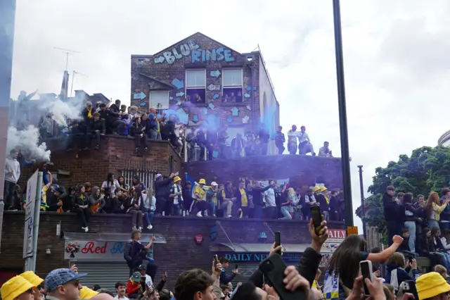 Dozens of young people on the roof of a business to catch a glimpse of the buses