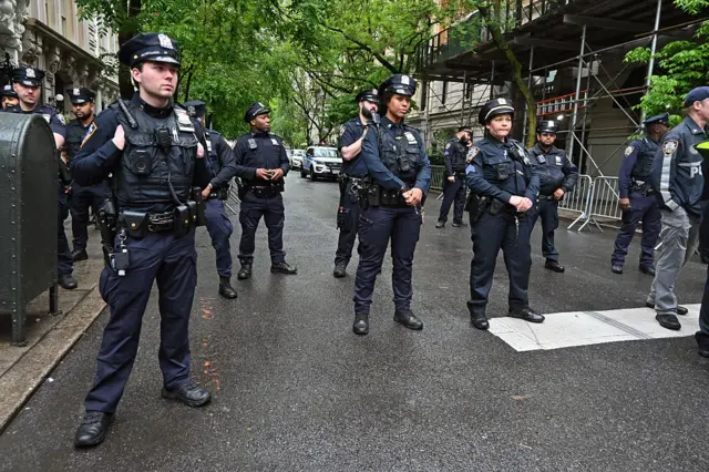 Police officers monitor a small crowd of pro-Palestinian protesters gathered outside the Met before the 2025 Met Gala at the Metropolitan Museum of Art.